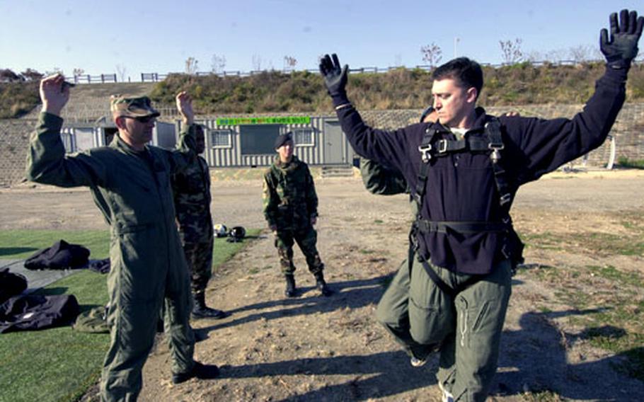 Stars and Stripes Korea Bureau Chief T.D. Flack, right, practices for his first tandem jump Wednesday at a drop zone near Seoul.