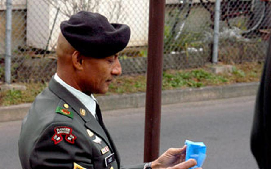 U.S. Army Garrison Japan Command Sgt. Maj. Eusebius P. Cadet holds the cover he just removed from the sign marking Camp Zama’s newly dedicated Coomer Drive, named for retired Command Sgt. Maj. Jimmie Coomer, who served at Zama before retiring from the Army.