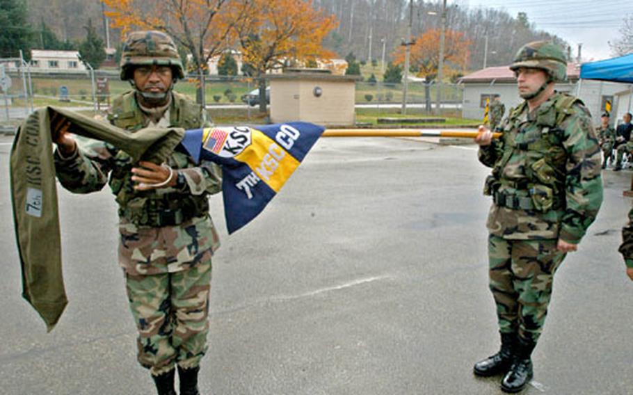 The 7th Korea Service Corps Company colors, held by KSC Battalion commander Lt. Col. Robert J. Paquin, are uncased at Camp Casey, South Korea, on Thursday during a ceremony handing over responsibility for transport of 2nd Infantry Division’s heavy equipment as part of the transformation of U.S. forces on the peninsula.
