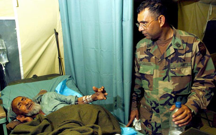 Sgt. 1st Class Mohammad Tabassum, a translator for the 212th MASH, considers the best response to an elderly Pakistani man being treated in the hospital.