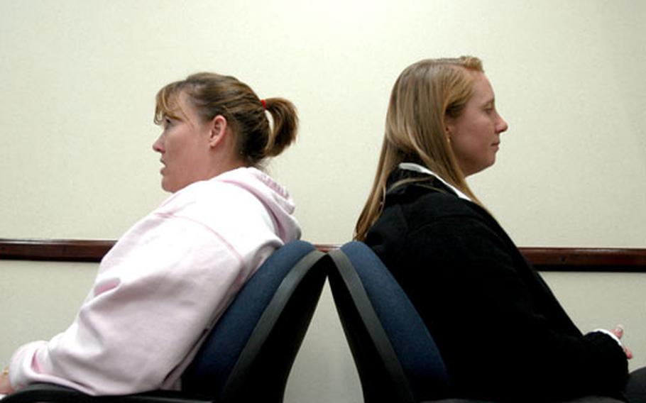 Sherri Light, left, a civilian employee, asks Capt. Meredith Ortiz, the base’s sexual assault response coordinator, her options in dealing with inappropriate sexual advances from her commander while role-playing during a recent victim advocate training session.