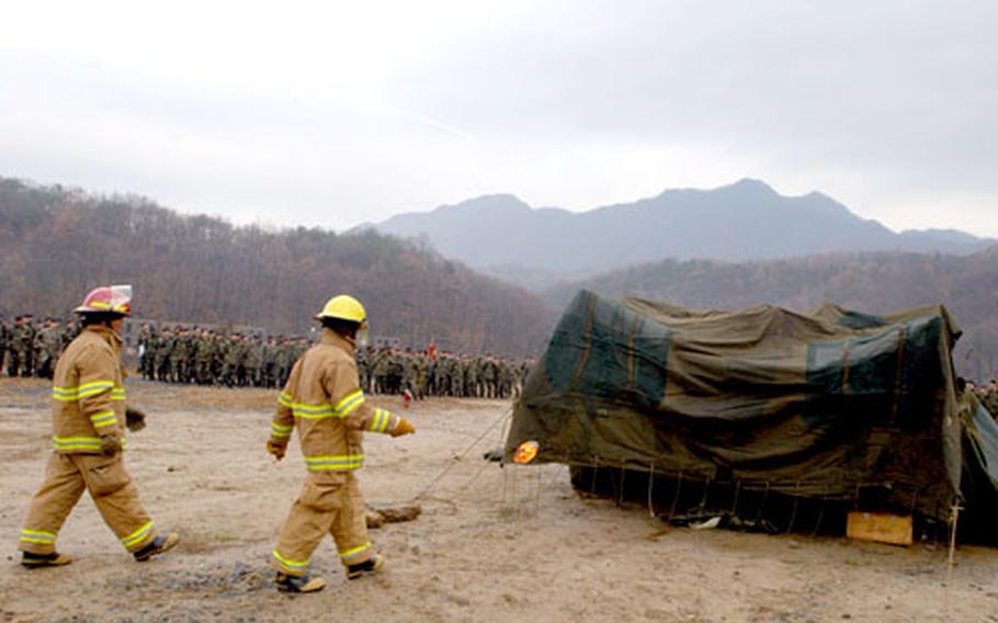 Firefighters prepare to set fire to a tent and its contents Thursday at Camp Casey, South Korea, while members of the Fires Brigade, 2nd Infantry Division look on.