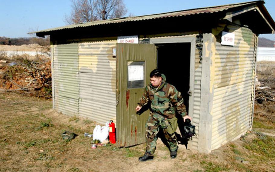 Second Infantry Division nuclear, biological and chemical instructor Sgt. Mark Crosby, 22, of Midland, Mich., emerges Tuesday from a smokehouse full of tear gas at North Star Range, South Korea.