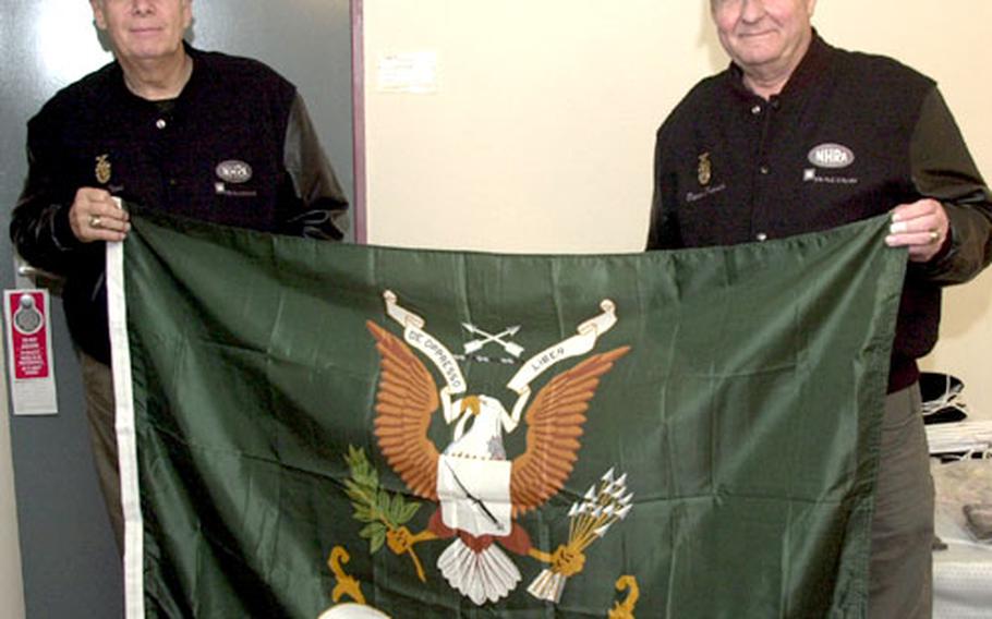 Wayne Reed, left, and Dieter Protsch pose in Reed’s Ramstein, Germany, billet with their flag from the U.S. Army Special Forces Association. Reed has made five visits just this year to Landstuhl just to thank soldiers wounded in Iraq and Afghanistan.