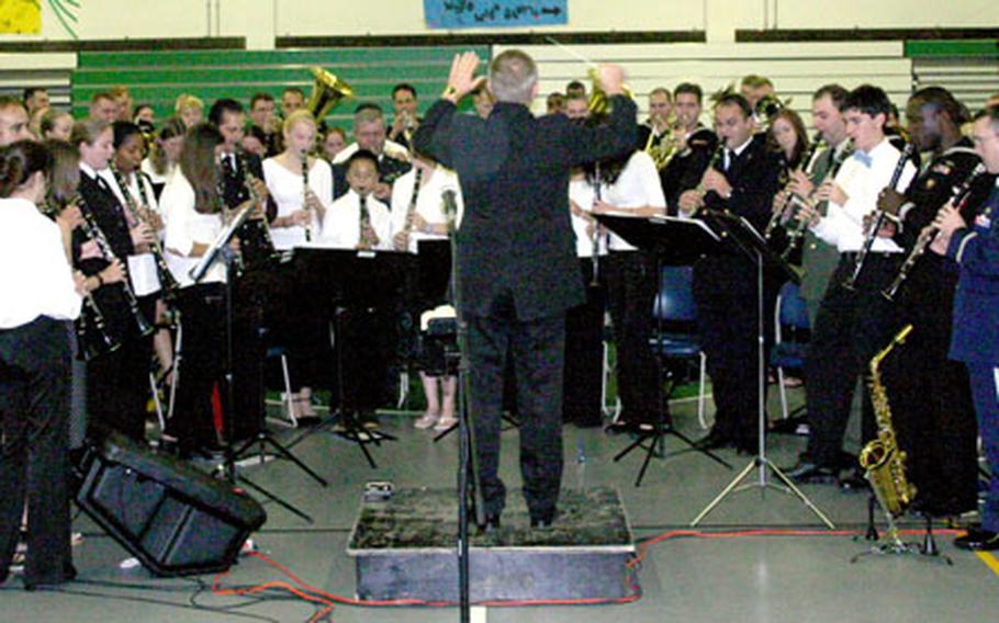 Naples (Italy) High School band director Gary Marvel conducts the performance of John Philip Sousa’s “The Stars and Stripes Forever” Thursday night.