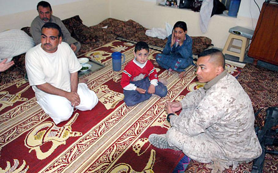 Lt. Col. Robert Glover visits with and apologizes to an Iraqi store worker Wednesday who was beaten by several Iraqi soldiers on joint patrol with Marines last week. Glover says apologizing for Iraqi forces takes up a significant portion of his time.