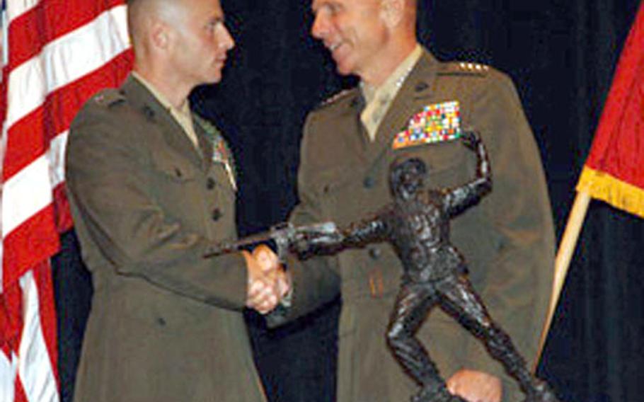 Marine Corps Commandant Gen. Michael W. Hagee, right, presents Capt. Christopher J. Bronzi the Leftwich Trophy for Outstanding Leadership.