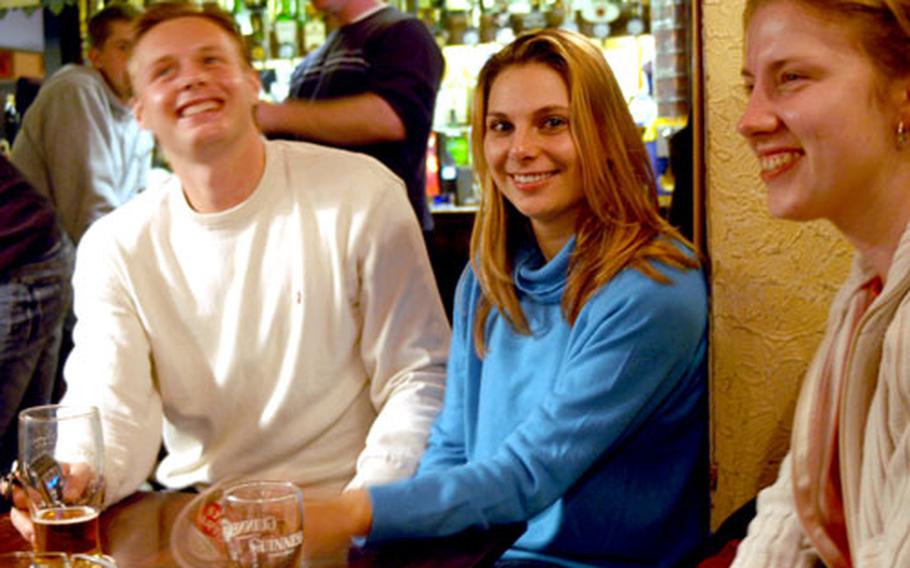 Czech Republic natives, left to right, Petr Zemek, Mirka Krockova and Petra Dudova enjoy a drink as business hours wind down at The Locomotive pub in Cambridge recently. The pub, like most in England, closed at 11 p.m., but starting Thursday it will be open until 2 a.m. on weekends.