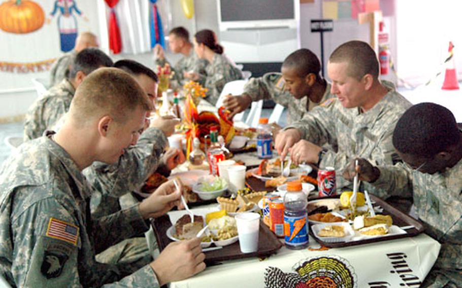 Soldiers at Forward Operating Base Warrior in Iraq dig in to their Thanksgiving feast.