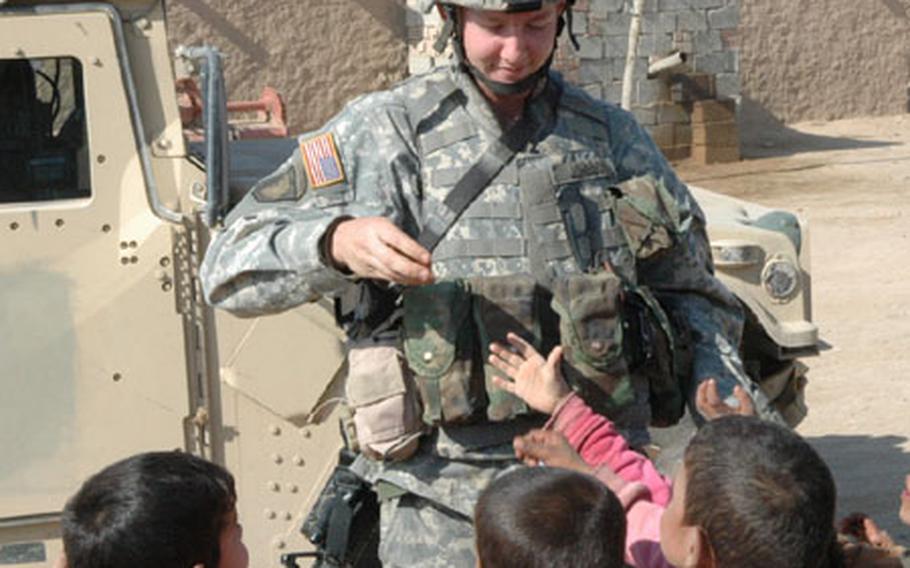 Pvt. Mark Johnson, 23, hands out candy and treats in a village near Hawija, Iraq.