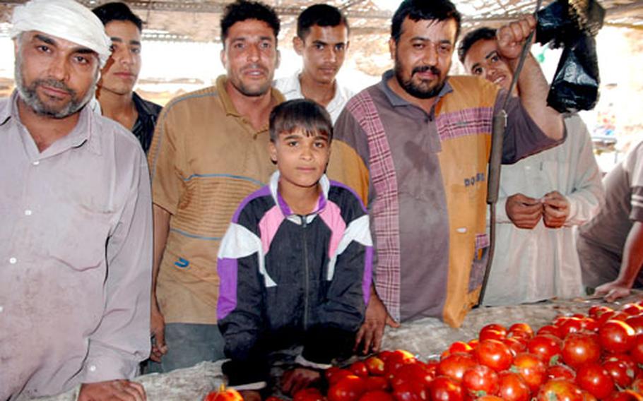 Death by tomato: That’s what vendor Radi Abd al-Hussein’s 12-year-old son, center, wants for Saddam Hussein. His father, however, was more blunt: “See you in hell,” he said.
