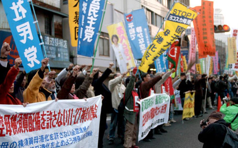 Protesters stop outside the main gate of Yokosuka Naval Base, Japan, on Sunday and chant their opposition to a number of recently announced U.S. military plans. Some 2,000 protesters marched from Yokosuka’s Daiei Mall to Yokosuka Chuo station.