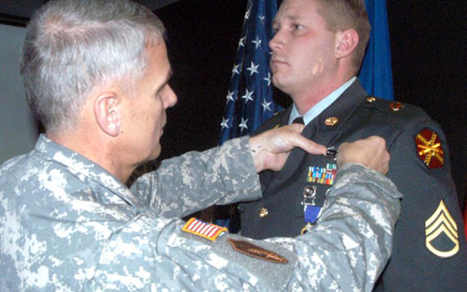 Staff Sgt. John Moyle, right, a military policeman assigned to Army Garrison Stuttgart, receives a Purple Heart, Combat Action Badge and Army Commendation Medal on Wednesday from Lt. Gen. Colby Broadwater III, the U.S. European Command chief of staff, during a ceremony at Patch Barracks in Stuttgart, Germany.