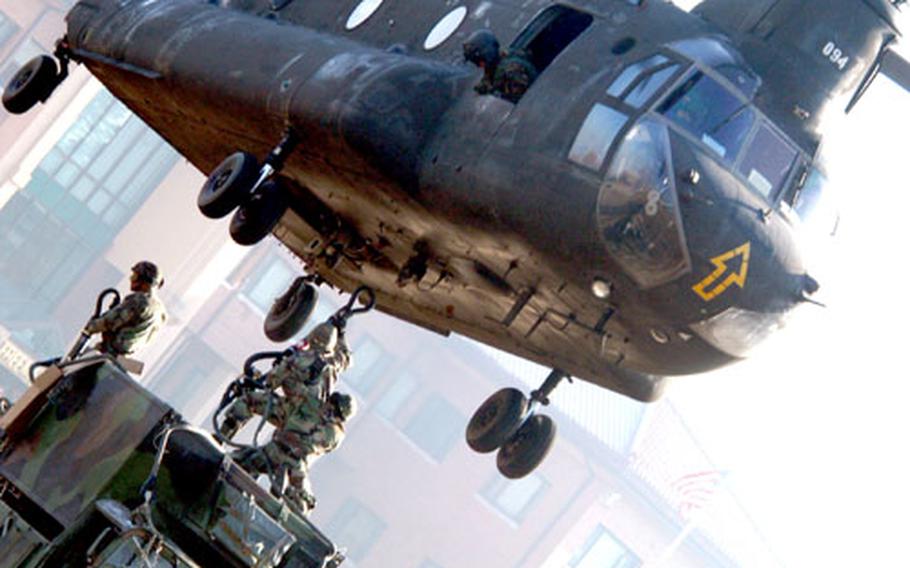 The "hook man" reaches up to sling load a Humvee and trailer to a Chinook helicopter during training for Special Troops Battalion, 2nd Infantry Division soldiers at Camp Red Cloud on Wednesday.