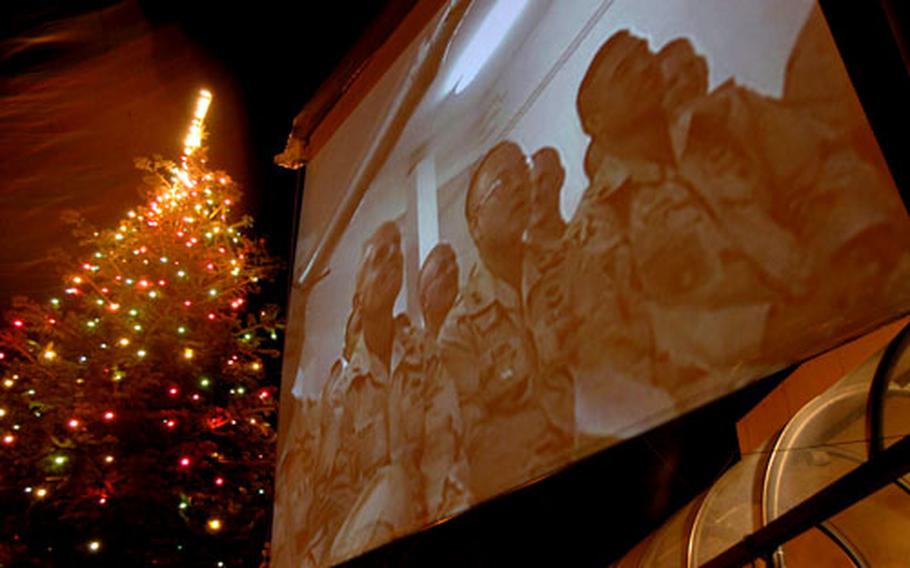 Southern European Task Force (Airborne) soldiers stationed at Bagram Air Base in Afghanistan admire the lit Christmas tree and watch the celebration at Caserma Ederle on Friday night via a video teleconference center hookup, giving them a glimpse of the holiday season back in Italy.