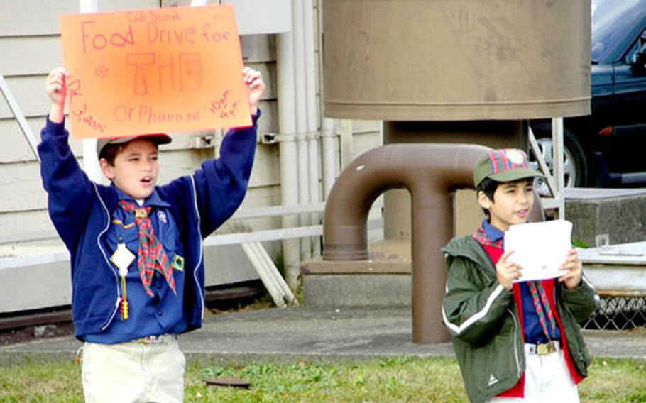 Cub Scout Webelos Kili Kaawaloa, left, and Steven Dykstra joined some 50 other Cub Scouts outside both Camp Zama and Sagamihara Housing Area commissaries on Saturday to collect food and donations to benefit the Aikeikai Orphanage in Machida.