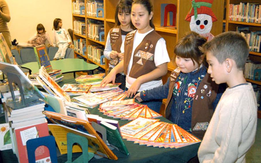 At the Camp Walker Library in Daegu, South Korea, on Saturday, members of Daegu’s Brownie Troop 17 take in some of the more than 250 books they donated to the library through a donation drive they mounted earlier this year. From left are Brownies Ryan Vega, Emily Cox, Caitlin Herztzendorf and Ryan Vega’s brother, Brandon Vega.