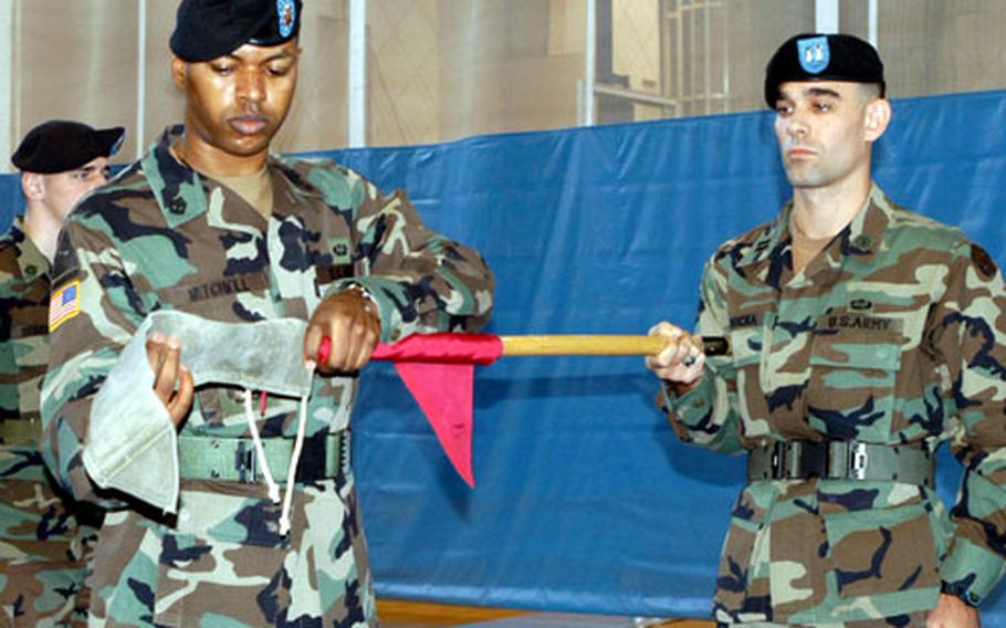 First Sgt. Rahsan Mitchell, front left, wraps up the colors of the 65th Ordnance Company Tuesday while company commander Capt. Joseph Borovicka holds the flag during the company's inactivation ceremony at Camp Casey, South Korea.