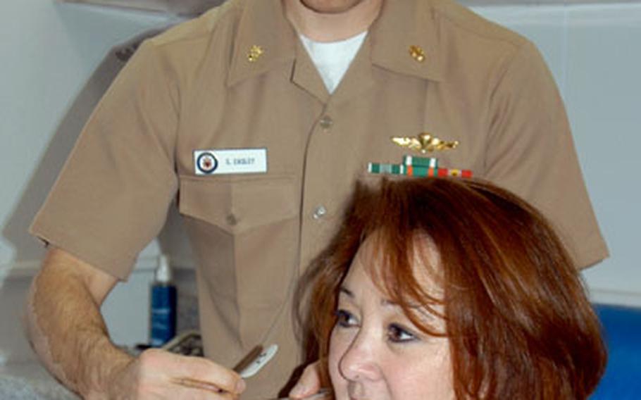 Navy Lt. Cmdr. Sean Easley, a board-certified physical therapist, applies electric stimuation to the shoulder of Naval Air Facilty Atsugi resident Cathy Knudson during a treatment. This fall, Easley began offering physical therapy services at Atsugi's Branch Medical Clinic, saving patients there a drive to another treatment facility.