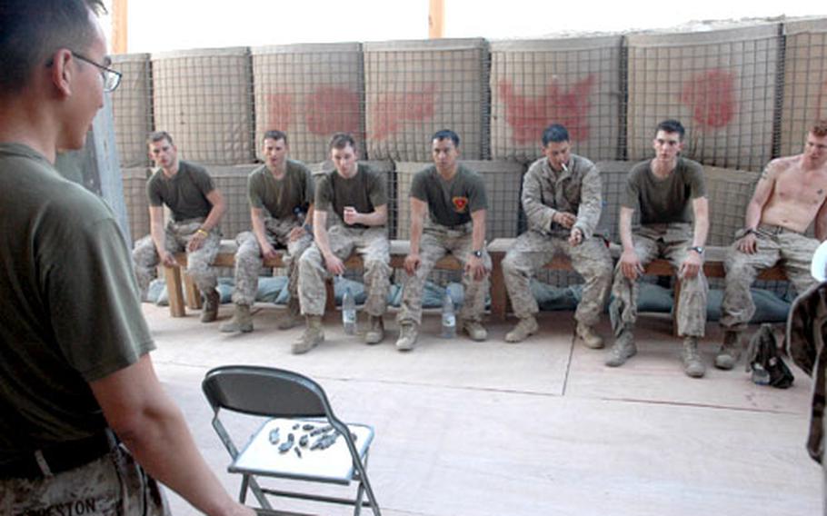 Staff Sgt. John Preston talks to a team of Marines shortly after a roadside bomb hit their patrol. He shows them pieces of shrapnel retrieved from the bomb crater.