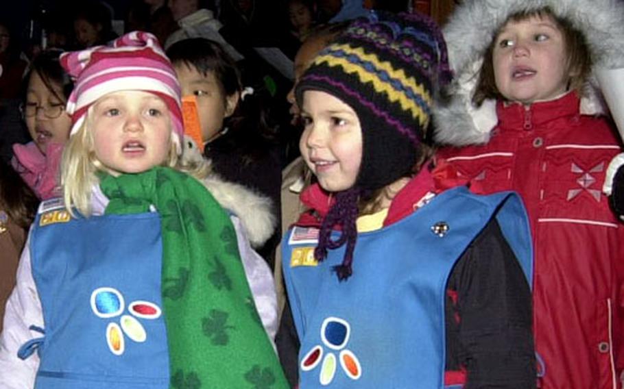 Girl Scouts sing Christmas tunes during the annual tree-lighting ceremony Thursday night on Yongsan Garrison, South Korea.