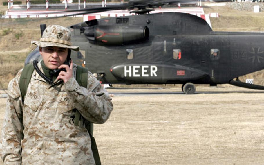 Lance Cpl. Troy Hayes, an air traffic controller with Marine Air Control Squadron-4 from Marine Corps Air Station Futenma, Okinawa, stands in front of a German helicopter in Shinkiari, Pakistan, last Saturday. Hayes is one of six Marines from his squadron serving in Pakistan who are attached to Marine Air Control Group 18.