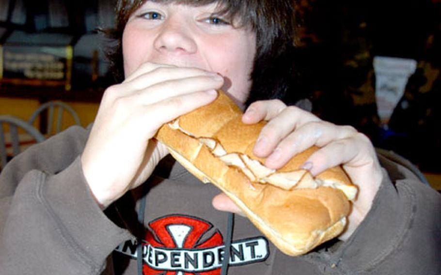 C.J. Cole, 15, bites into a Subway sandwich Friday at Misawa Air Base, Japan. Cole was among a huge crowd that flocked to Subway, which opened Friday in the food court.