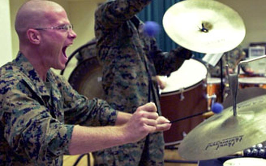 Sgt. Kristofer Hutsell, foreground, and Cpl. Carl Michael help in the dramatic ending of a rocking rendition of the Christmas classic “Carol of the Bells” during III Marine Expeditionary Force Band practice Friday on Camp Foster, Okinawa.