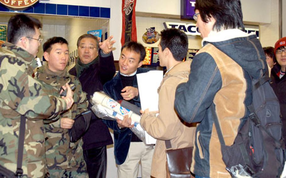 Professor Kim Seung-Hwan points to a Chinese restaurant while his students listen to advice about what they should eat in a food court on Yongsan Garrison on Friday afternoon.