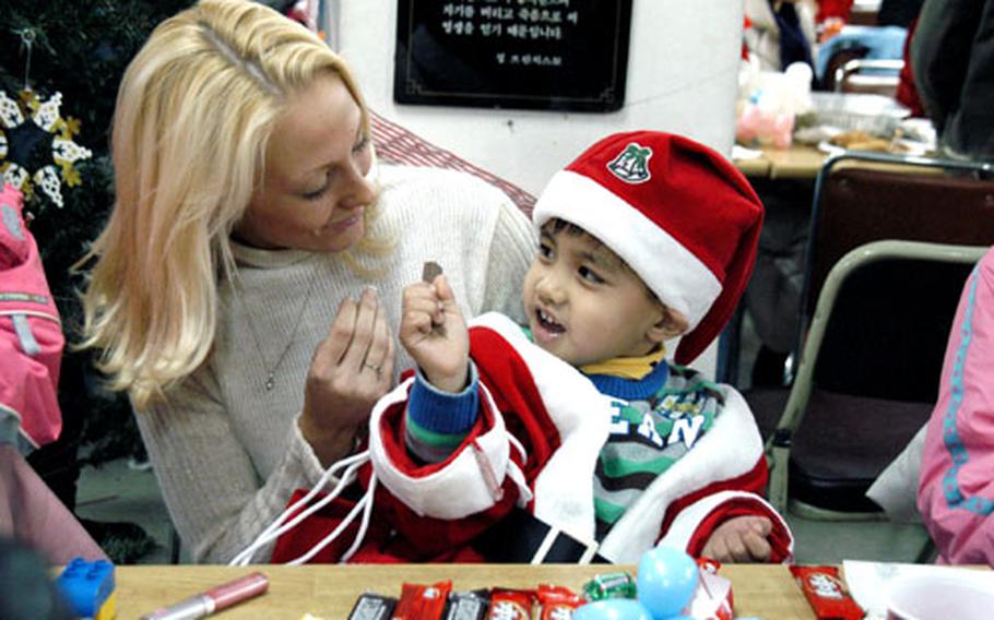 Second Lt. Holley Thomas, 22, of Waterloo, N.Y., plays with Joon, a boy who receives help from Pearl S. Buck International Korea. The charity organization helps biracial children.
