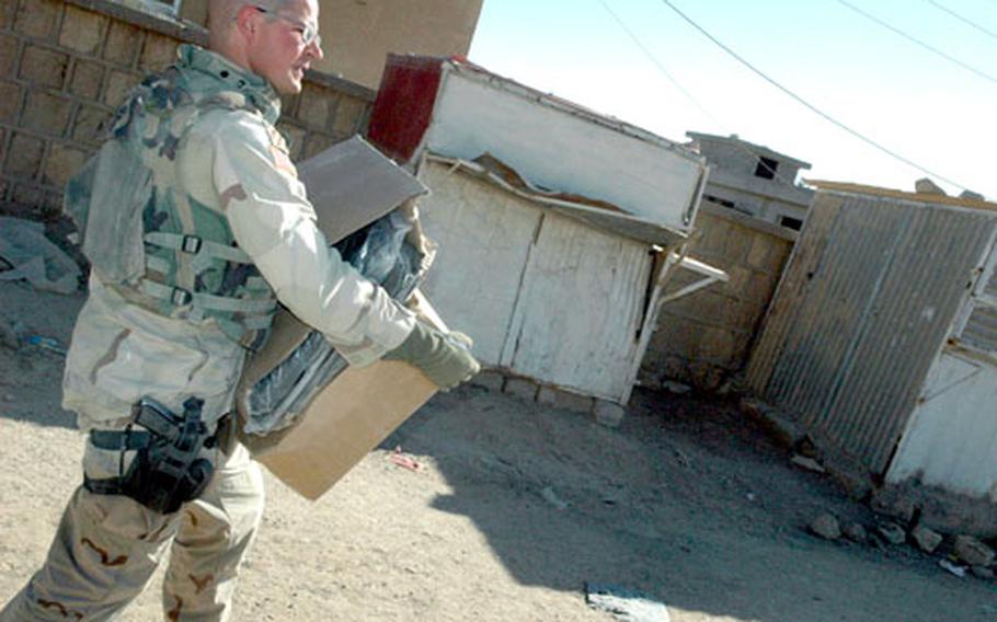 Staff Sgt. Corey Tondre, 25, of San Antonio, Texas, lugs a load of body bags to Tal Afar General Hospital Saturday in preparation for possible violence in the days leading up to the Thursday’s parliamentary election in Iraq. Tondre belongs to 3rd Platoon, Eagle Troop, Sabre Squadron, 3rd Armored Cavalry Regiment.