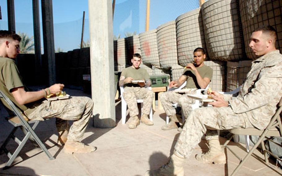 Several U.S. Marines enjoy Thursday morning breakfast, the once-a-week hot meal at their small post outside Fallujah.