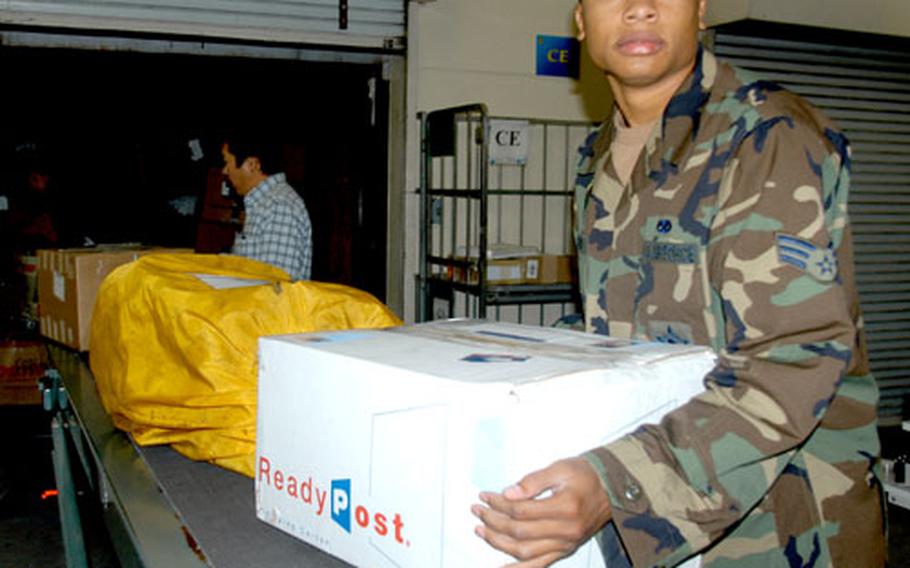 Senior Airman Gregory Howard, a postal services center clerk at Misawa Air Base, Japan, unloads holiday packages Monday afternoon at Misawa’s post office.
