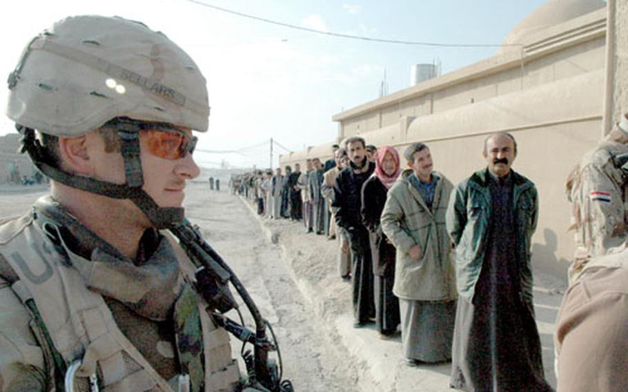 Capt. Jesse Sellars, commander of Fox Troop, Sabre Squadron, 3rd Armored Cavalry Regiment, observes a line of Iraqis waiting to vote in southwestern Tal Afar on Thursday.