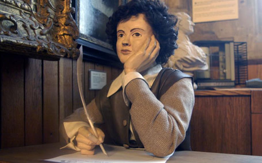A young Oliver Cromwell sits at a replica of a desk from the early 1600s period in which he attended school in the building that is now a museum to Cromwell, one of the few commoners to become leader of England.