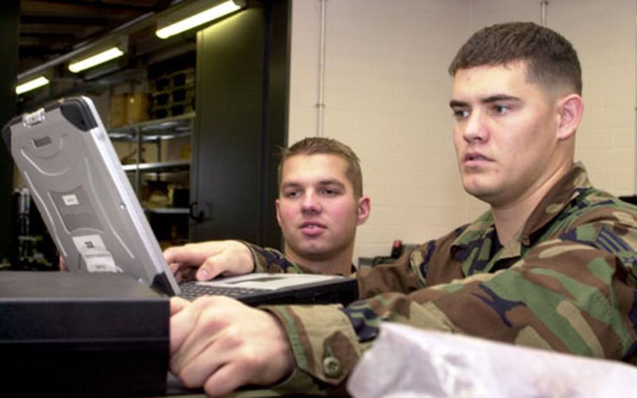 Senior Airmen Jon Anderson, left, and David Carnes, 606th Air Control Squadron theater deployable communications journeymen, configure a Promina multiplexer as it would be used in the field at Spangdahlem Air Base, Germany, on Wednesday. The multiplexer links multiple communications lines into one line.