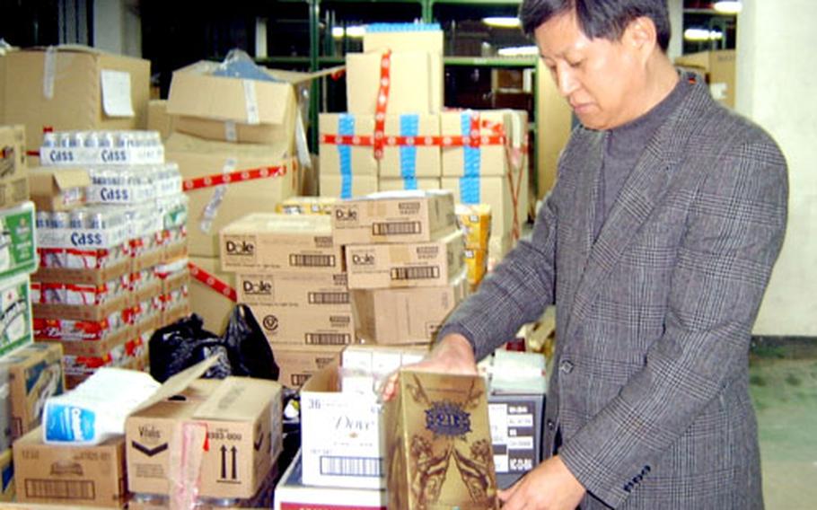A senior investigator at the Seoul Customs Service, Kim Jong-mu, looks at 21-year-old Scotch whiskey, which can cost as much as 300,000 won ($300) in Korea. The whiskey came from an AAFES store in South Korea and was taken from suspected black marketers, Kim said.