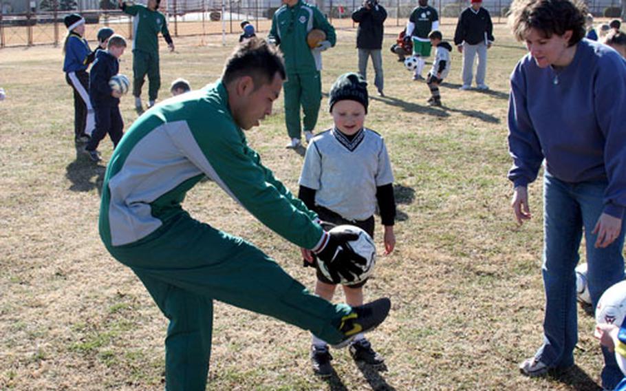 A former Tokyo Verdy soccer player, now a coach with the organization, delivers tips on ball-handling to a member of Yokota’s youth program during a two-hour clinic Saturday at Wilkins Field. The Inagi-shi-based club competes in the Japan Professional Football League, more popularly known as the J-League.