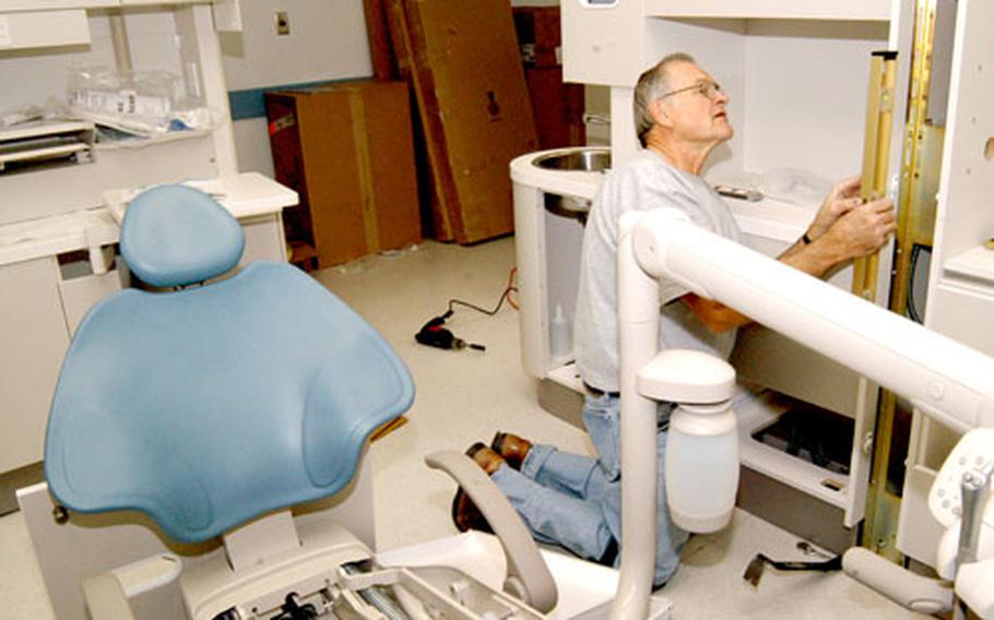 At Camp Walker Dental Clinic in Daegu, South Korea, in November, Ron Gaumer, a contractor with Austin Dental Equipment Company, checks the alignment of newly installed cabinets during the final phase of the clinic’s $2.3 million renovation, which began in December 2004. A dental treatment chair in the foreground awaits assembly.