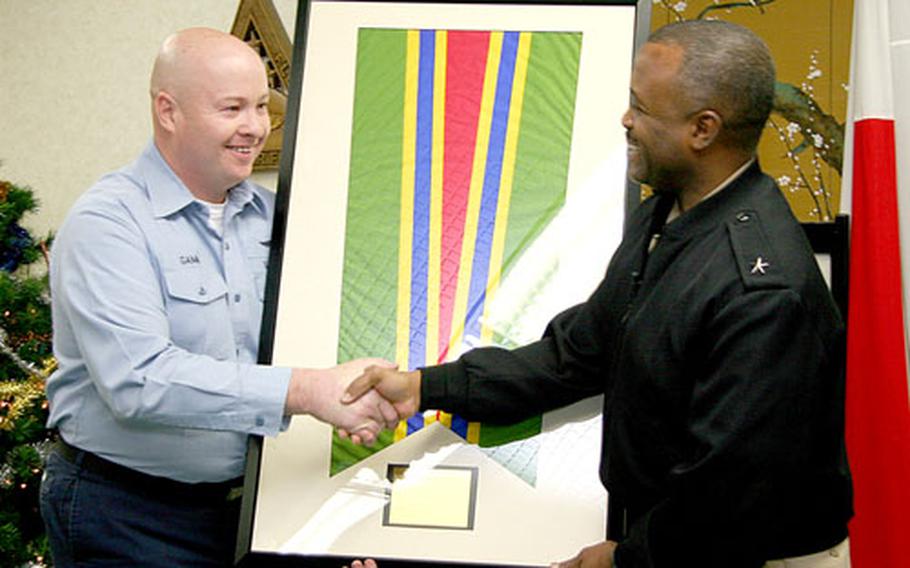 Commander of Fleet Air Western Pacific, Rear Adm. Arthur Johnson, right, presents the Meritorious Unit Commendation ribbon to Petty Officer 1st Class Gerald Gamm, the command’s 2005 Sailor of the Year, as a representative for the entire command, during an award ceremony on Monday.