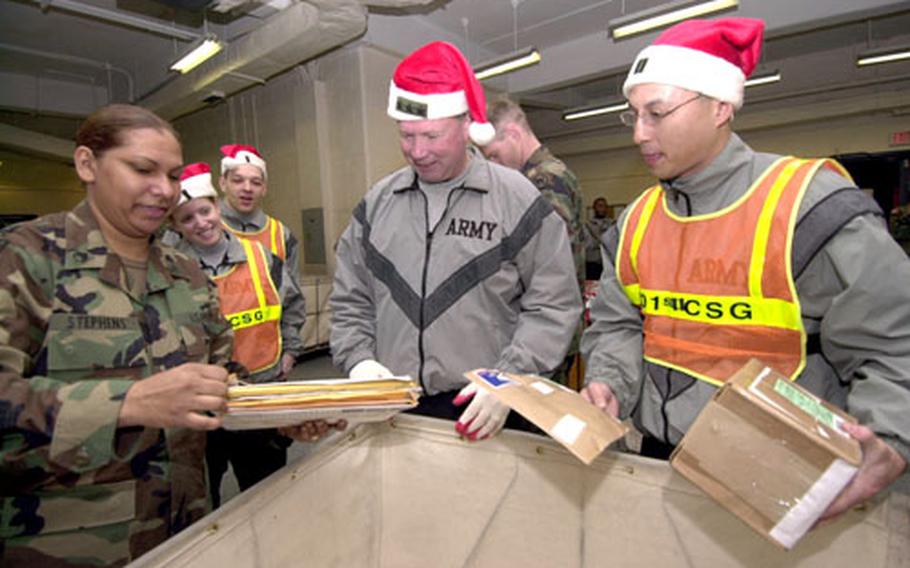 Staff Sgt. Paula Stephens, left, Lt. Gen. Charles Campbell and Capt. Mark Ripley sort mail Wednesday morning in the Yongsan Garrison post office.