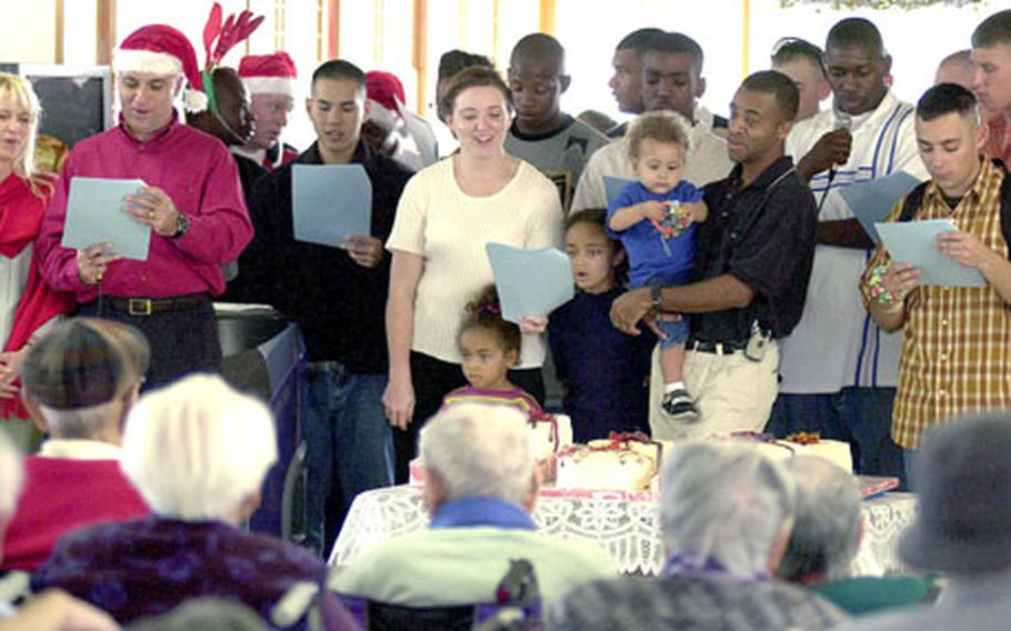 The group from Camp Hansen sings Christmas carols for the nursing home residents. Marines from the 7th Communications Battalion have been volunteering at the home twice each month for the past 13 years.
