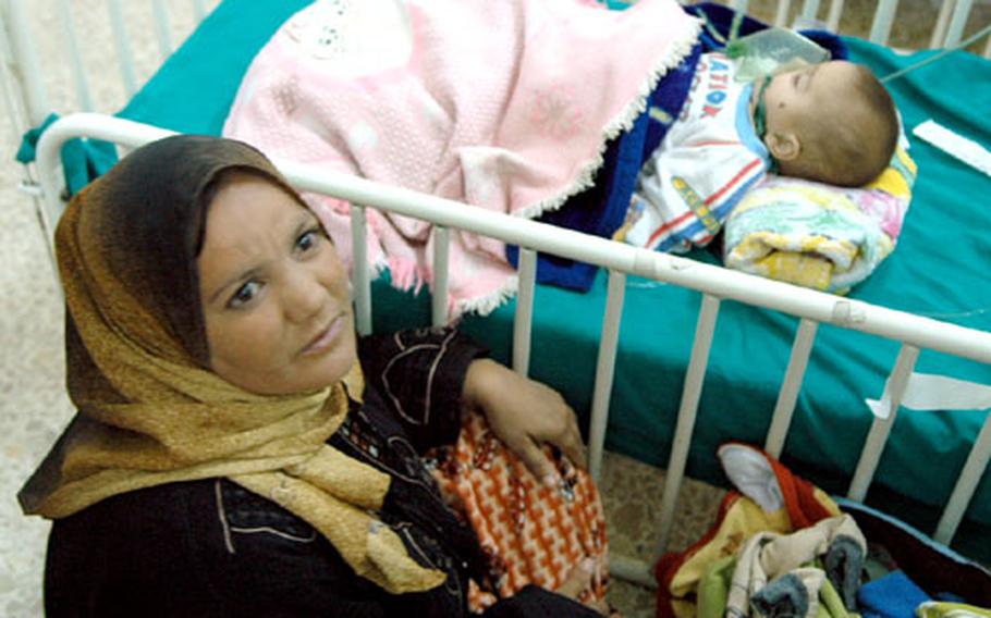 A woman keeps watch over her ill son at the Alwaiya Children's Hospital in Baghdad.