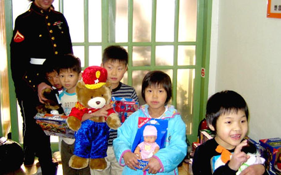 Children at the Cha Shin orphanage in Wonju, South Korea, hold new toys delivered to them on Wednesday by U.S. Marines who drove in from Seoul.