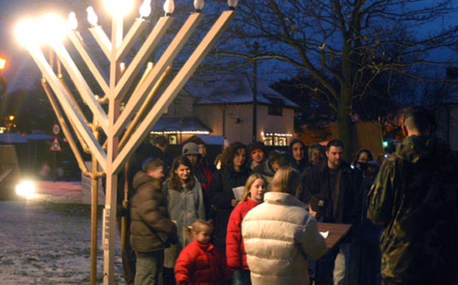 In the light of three electric Hanukkah candles Tuesday at RAF Mildenhall, England, members of the local Jewish community gathered for the menorah lighting on the base.
