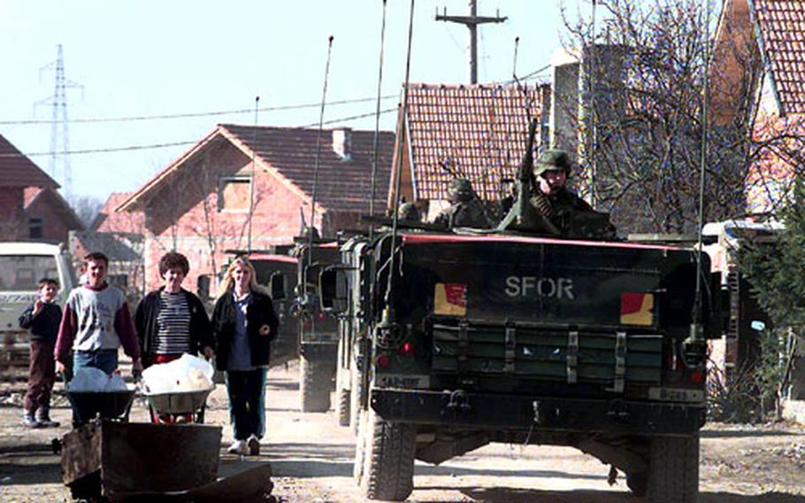 A convoy of 1st Armored Division Humvees patrols Stari Rasadnik, a Bosnian Muslim area, in February 1998.