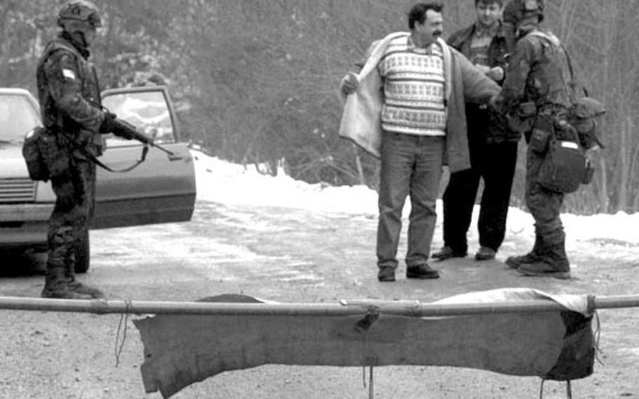 In February, 1996, on IFOR Route Python Near Kladanj, Bosnia and Herzegovina, American IFOR troops check individuals and cars for weapons at what was once the front line between the warring factions.