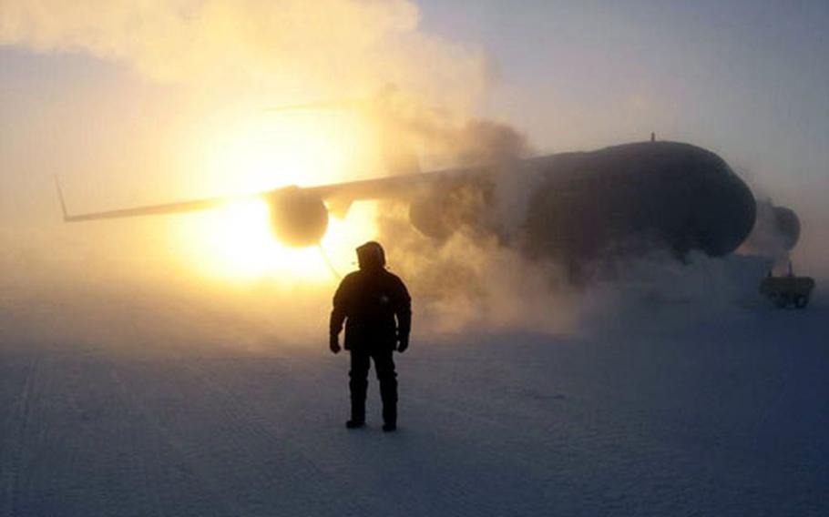 A McChord Air Force Base crewmember stands in front of a C-17 at McMurdo Station, Antarctica.