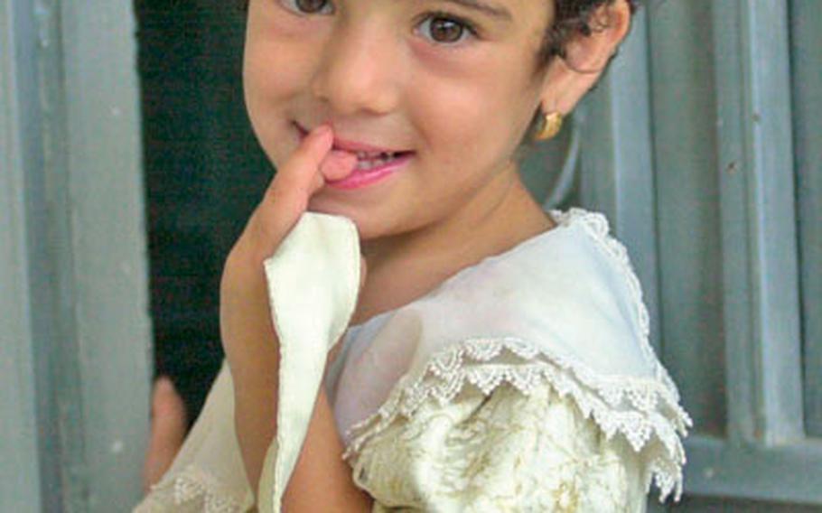 A young Iraqi girl comes out of her house to watch a passing patrol of U.S. and Iraqi soldiers in July. For 2nd Brigade soldiers in Ramadi, it was tough to tell what kind of reception local residents would give them on any given day.