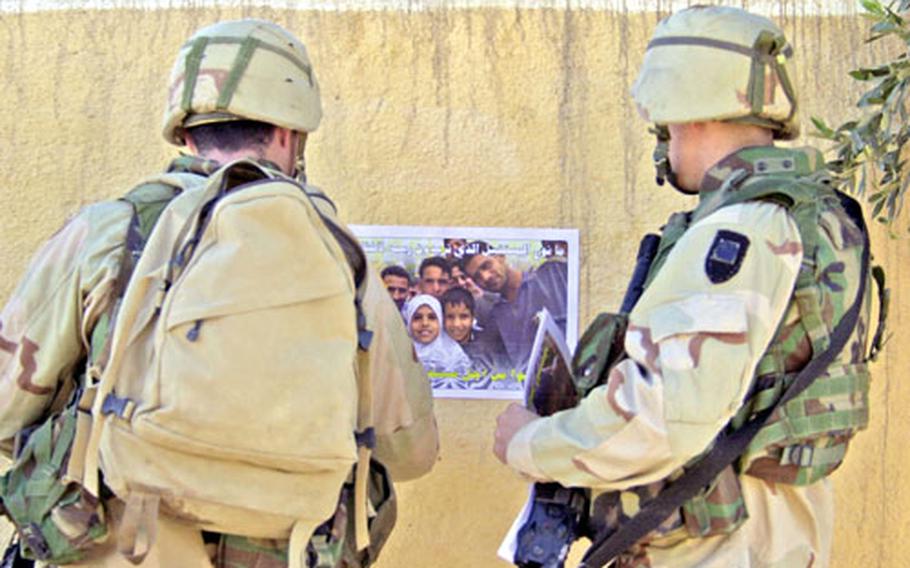 In January, soldiers with the 1st Battalion, 503rd Infantry Regiment put up posters in Ramadi urging Iraqi citizens to participate in the upcoming elections.